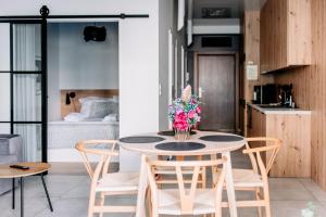 una mesa con sillas y un jarrón de flores en BOSZKOWO Apartament "EDEL" 106 Aquarius, en Boszkowo-Letnisko