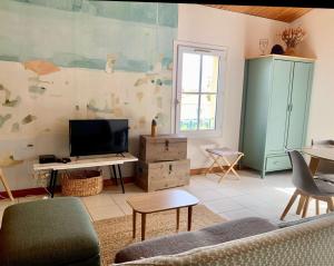een woonkamer met een bank en een tv bij Appartement duplex "Atlantis" proche du port in Saint-Martin-de-Ré