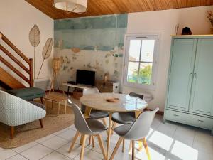 een woonkamer met een tafel en stoelen bij Appartement duplex "Atlantis" proche du port in Saint-Martin-de-Ré
