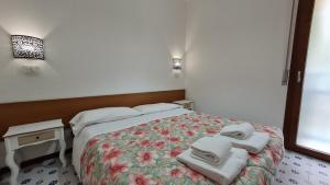 sypialnia z łóżkiem i ręcznikami w obiekcie Panorama Apartment Peschiera w mieście Peschiera del Garda