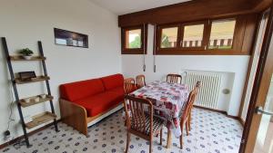 salon ze stołem i czerwoną kanapą w obiekcie Panorama Apartment Peschiera w mieście Peschiera del Garda