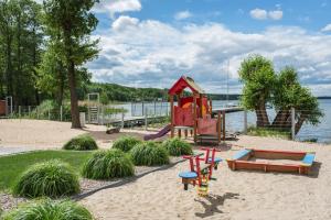 un parque infantil con un tobogán y un banco en la arena en BOSZKOWO Apartament "EDEL" 106 Aquarius, en Boszkowo-Letnisko