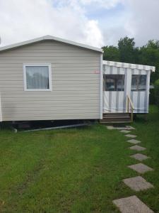 una casa con una puerta y un patio de césped en Mobil-home 949, en Les Mathes