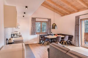 una cucina e una sala da pranzo con tavolo e sedie di Schartneralm Zirbel Family a Collalbo
