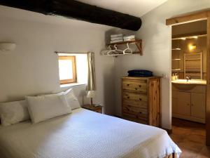 a bedroom with a white bed and a sink at LA CONFISERIE in Saint-Sauveur-de-Cruzières