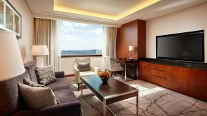 a living room with a couch and a flat screen tv at Lotte Hotel Ulsan in Ulsan