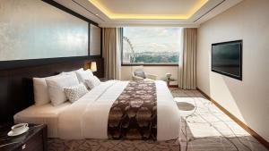 a hotel room with a large bed and a window at Lotte Hotel Ulsan in Ulsan