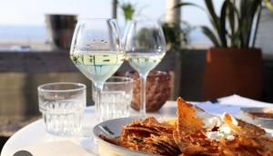 two glasses of white wine and a plate of food at La casa de Pernilla Awesome apartment, near beach in centre of town in Puerto de Mazarrón +22 photos
