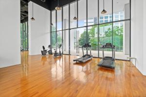 a gym with cardio machines in a large room with wood floors at Lumina by Kozystay - Cilandak in Jakarta