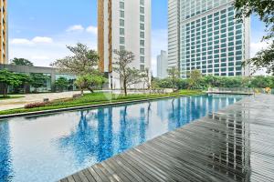 a swimming pool in a city with tall buildings at Lumina by Kozystay - Cilandak in Jakarta