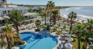 an aerial view of a resort with a swimming pool and the beach at Golden Bay Beach Hotel in Larnaca