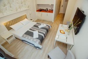 a small bedroom with a bed and a table at Sunshine Apartments Batumi in Batumi