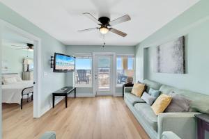 a living room with a couch and a ceiling fan at Boardwalk Condos in Gulf Shores