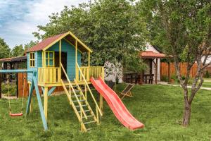 a playground with a slide and a play house at Chata Mazurska in Orzysz