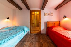 two beds in a bedroom with wooden floors at Chata Mazurska in Orzysz