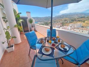 a table with plates of food on a balcony at Suculenta Ático dúplex Garaje La Herradura in La Herradura