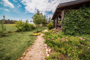 a garden path next to a house with flowers at Chata Mazurska in Orzysz