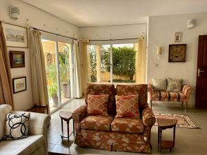a living room with a couch and a large window at Two bedroom villa with private swimming pool and garden in Almadies in Dakar