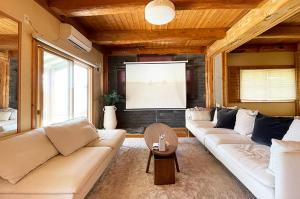 a living room with two couches and a television at 九十九里 Sunrise Log in Kujukuri +15 photos