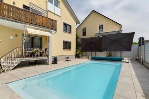 a swimming pool in front of a building with a house at Moderne offene Dachgeschoßwohnung in Linx
