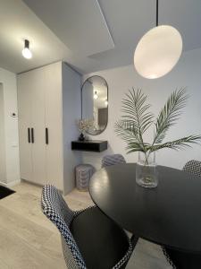 a dining room with a table and chairs and a mirror at Malūno vilos in Palanga