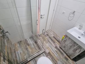 a bathroom with a shower and a toilet and a sink at Blue Sea View Apartment in Sarandë +12 photos