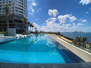 a large swimming pool with a view of the ocean at APEC Mandala Mũi Né in Mui Ne
