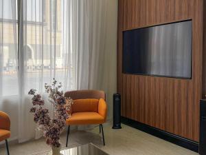 a living room with a tv and a chair and a plant at ارجان بارك القادسية in Riyadh +28 photos