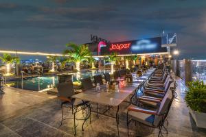a restaurant with tables and chairs on the roof of a building at Le Meridien Hyderabad in Hyderabad
