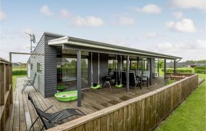 a house with a deck with chairs on it at Holiday Home Ellemose in Skovby