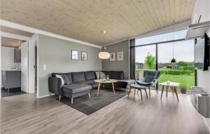 a living room with a couch and chairs and a table at Holiday Home Ellemose in Skovby