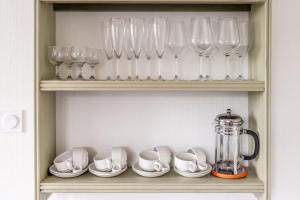 a shelf with glasses and cups and a blender at La maison des chevaux in Saint-Vran