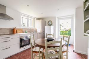 a kitchen with a table and chairs in a kitchen at La maison des chevaux in Saint-Vran +15 photos