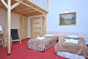 a hotel room with two beds and a chair at Pensjonat Stańczyk in Krakow