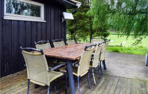 a wooden table and chairs on a deck at Lovely Home In Enebakk With Wifi in Omberg