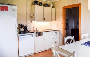 a kitchen with white cabinets and a white refrigerator at Lovely Home In Enebakk With Wifi in Omberg