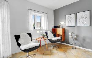 a living room with two chairs and a table at Holiday Home Horns Bjerge Vi in Blåvand