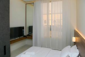 a bedroom with a white bed and a television at ارجان بارك القادسية in Riyadh