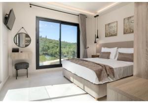 a bedroom with a large bed and a large window at Villa Zografia in Alikanas