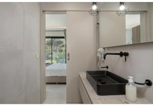 a bathroom with a sink and a mirror and a bed at Villa Zografia in Alikanas +36 photos