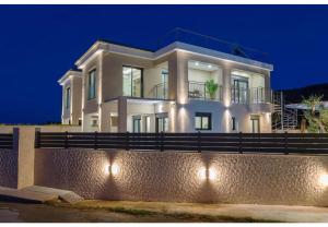 a large white house at night with lights at Villa Zografia in Alikanas