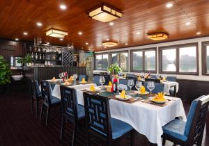 een eetkamer met tafels, stoelen en ramen bij Garden Legend 2 cruise in Ha Long