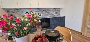 奥尔什蒂内克Arkady House的厨房配有带鲜花和酒杯的桌子