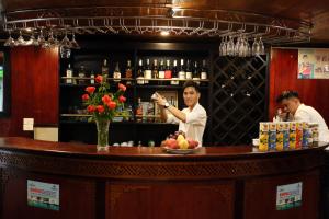 een man achter een bar in een restaurant bij Garden Legend 2 cruise in Ha Long