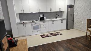 a kitchen with white cabinets and a stainless steel refrigerator at Luxury 2 bed apartment by Albert in Roşu +8 photos