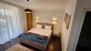 a bedroom with a bed with two towels on it at Luxury 2 bed apartment by Albert in Roşu