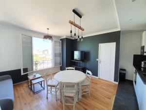 a living room with a white table and chairs at Au pied des transports Appartement lumineux in Vincennes +2 photos