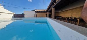 una piscina con acqua blu in un edificio di Casa Rural del Pantano 4 Estrellas a Buenache de Alarcón