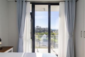 a bedroom with a bed and a large glass window at 8 at Bella Mare Estate in Gqeberha +45 photos