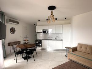 Una cocina y una sala de estar con mesa y sillas. en Apartment in Thalassa Beach Resort & Spa Retreat, en Vokolidha